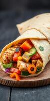 Delicious chicken fajita wrap with colorful vegetables served on a wooden board photo