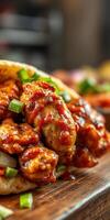 Delicious spicy chicken wings served with fresh herbs on a wooden table at a cozy restaurant photo