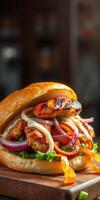 Grilled chicken sandwich loaded with fresh vegetables and creamy sauce served on a bun photo