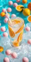 Refreshing citrus drink surrounded by colorful candy on a bright summer day photo