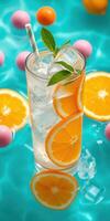 Refreshing summer citrus drink with ice and mint surrounded by colorful poolside decor photo