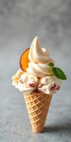 Delicious ice cream cone topped with creamy swirl and garnished with peach slice and mint leaf photo