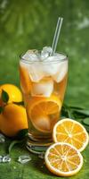 Refreshing iced orange beverage served in a tall glass with ice and fresh fruit on a green background photo