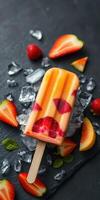 Colorful fruit popsicle with fresh strawberries and mint on a dark slate background photo