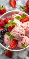 Delicious strawberry ice cream topped with fresh berries and mint leaves served in a bowl photo