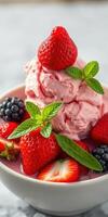 Delicious strawberry and blackberry ice cream sundae topped with fresh berries and mint leaves ready to enjoy photo