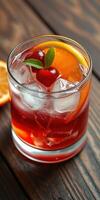 Colorful cocktail with ice, cherries, and orange slice on rustic wooden table photo