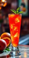 Refreshing red cocktail garnished with mint leaves in a tall glass surrounded by citrus fruits photo