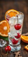 Refreshing beverage with cherries and orange slices served on wooden table with ice cubes photo