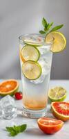 Refreshing citrus beverage served with ice and garnished with mint on a marble surface photo