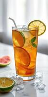 Refreshing iced tea garnished with citrus slices and mint on a marble surface during a sunny day photo