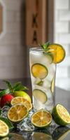 Refreshing lemonade drink served with lime and mint on a counter with fresh fruit photo