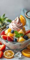Refreshing fruit salad topped with swirled cream served in a bowl on a rustic table photo