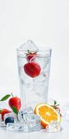 Refreshing summer drink with strawberries, blueberries, and orange slices served in a glass with ice cubes photo