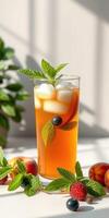 Refreshing iced tea with fruits and mint leaves on a sunny table photo