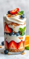 Colorful and delicious layered dessert featuring yogurt, granola, and fresh fruits including strawberries and blueberries photo