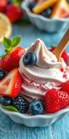 Delicious frozen yogurt topped with fresh berries served in a bowl on a blue wooden table photo