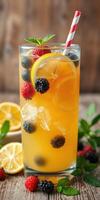 Refreshing summer beverage with citrus and berries served in a tall glass photo