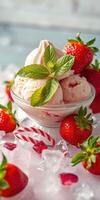 Strawberry ice cream served in a bowl surrounded by fresh strawberries and mint leaves on a bed of crushed ice photo