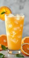 Refreshing orange drink garnished with citrus slices on a marble countertop during a sunny afternoon photo