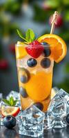 Refreshing fruit cocktail served in a glass with ice and garnishes on a sunny day outdoors photo