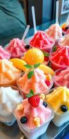 Colorful frozen desserts displayed in cups with fresh fruit garnishes on a sunny day photo