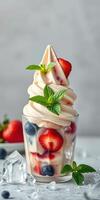 Delicious soft serve ice cream topped with fresh strawberries and blueberries served in a glass cup photo