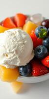 Fresh fruit salad topped with creamy vanilla ice cream served in a white bowl photo