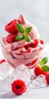 Fresh raspberry sorbet served in a glass bowl with mint leaves and ice photo