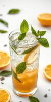 Refreshing citrus and mint beverage served over ice in a tall glass with slices of orange and fresh mint leaves photo