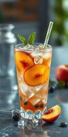 Refreshing peach beverage with ice served in a glass with mint leaves on a stylish dining table photo