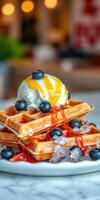 Delicious waffles topped with ice cream, blueberries, and syrup on a marble table photo