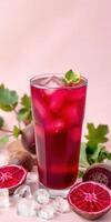Refreshing beverage with vibrant color and garnishes on a soft pink background photo