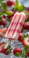 Refreshing strawberry popsicle sits on crushed ice with fresh strawberries and mint leaves surrounding it photo