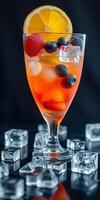 Refreshing fruit cocktail garnished with orange, raspberry, and blueberry on a dark background photo
