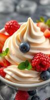 Creamy dessert topped with fresh berries and mint leaves in a bowl photo