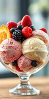 Delicious bowl of ice cream topped with fresh berries and fruit served in a glass dessert dish photo