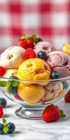Colorful ice cream dessert served in a clear bowl with fresh berries and mint on a bright checkered tablecloth photo