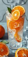 Refreshing citrus drink served in a tall glass with ice and garnished with orange slices photo