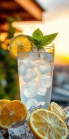 Refreshing citrus drink served with ice and mint at sunset photo