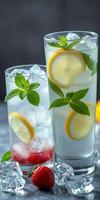 Refreshing lemon and mint beverages served over ice with strawberries on a grey background during a summer gathering photo