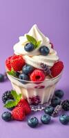 Fresh berry parfait with cream and mint served in a glass on a vibrant purple background photo