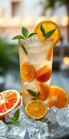 Refreshing citrus drink served in tall glass with ice and garnished with mint leaves photo