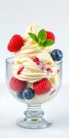 Delicious dessert featuring creamy vanilla ice cream topped with fresh raspberries and blueberries photo