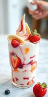 Colorful frozen dessert with strawberries, bananas, and mixed fruits in a glass on a marble table photo