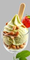 Creamy green tea ice cream topped with almonds and a fresh strawberry in a glass cup photo