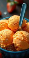 Scoop of vibrant orange ice cream in a bowl with a spoon on a dark surface photo