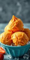 Delicious orange ice cream scoops served in a blue bowl with fresh strawberries on a cool stone surface photo