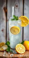 Refreshing lemonade with mint and ice served in a tall glass on a wooden table photo