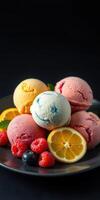 Colorful scoops of ice cream with fresh fruit on a black plate create a delightful dessert arrangement photo